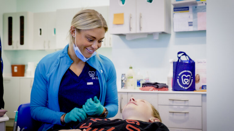 Richmond Pediatric Dentistry & Orthodontics | 5 Locations 4 Dr. Payton Cook smiling with a patient in the orthodontic chair at RPDO